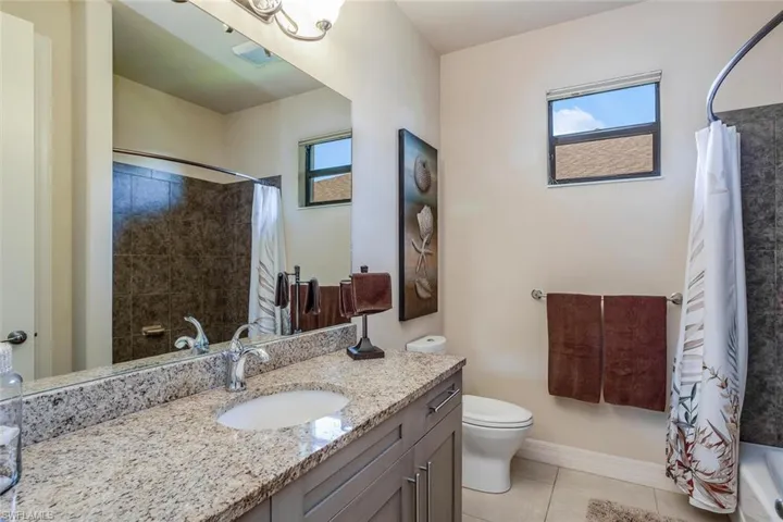 Bathroom with vanity, light tile patterned floors, and shower / bath combination with curtain