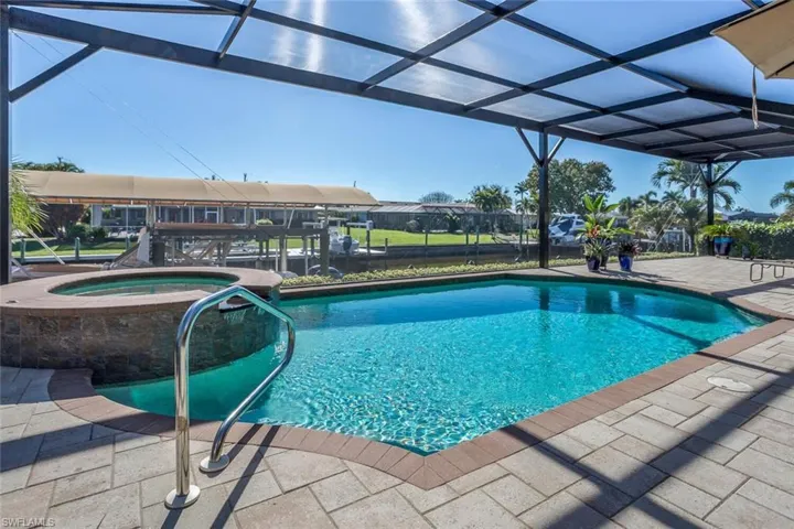 View of pool with a patio, a lanai, and a pool with connected hot tub