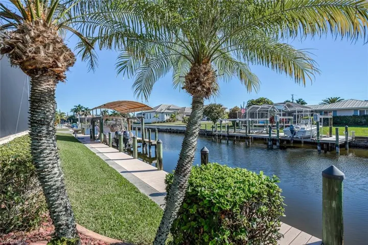 Dock featuring a water view, boat lift, and a residential view