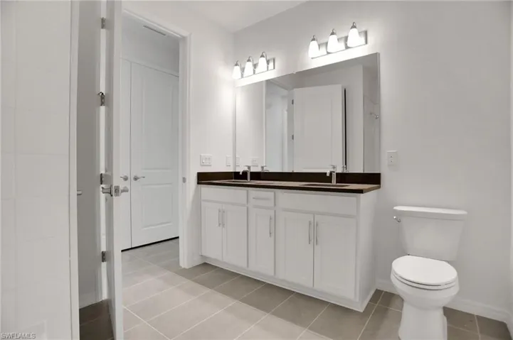 Bathroom featuring double vanity and light tile patterned floors