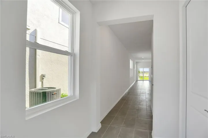 Hallway with plenty of natural light and light tile patterned flooring