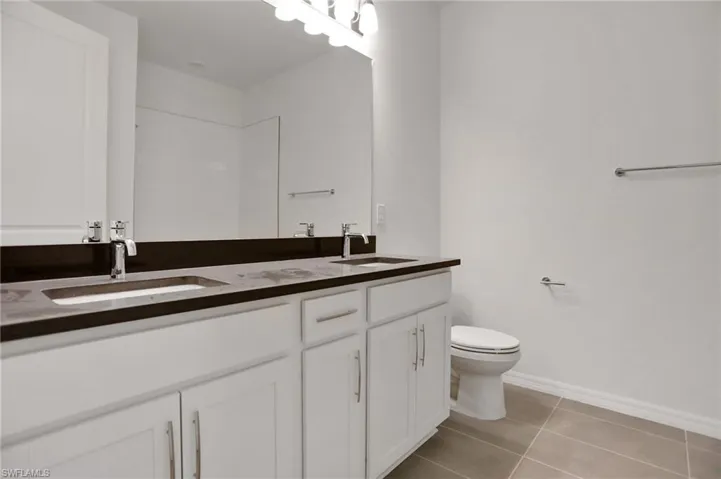 Full bathroom featuring double vanity and light tile patterned floors