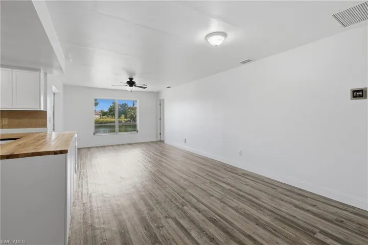 Unfurnished living room with light wood-style flooring and ceiling fan