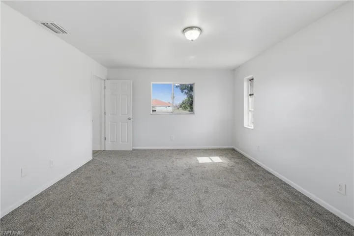 Spare room featuring carpet floors and baseboards