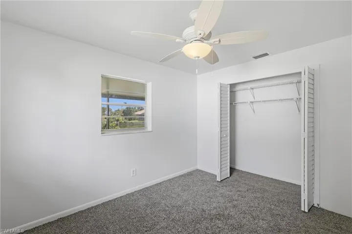 Unfurnished bedroom with carpet flooring, a closet, and a ceiling fan