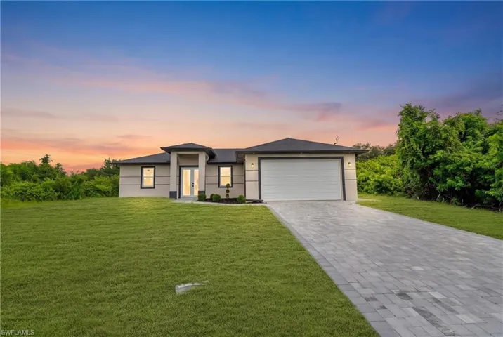 Single-story residence featuring a smooth stucco exterior, decorative banding, a paved driveway, and a two-car garage