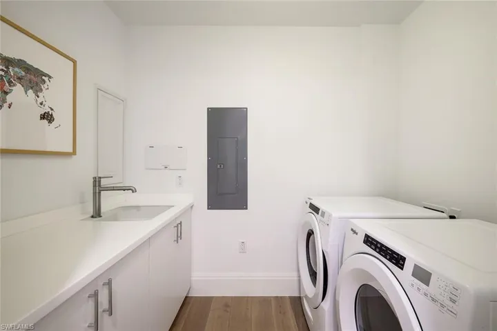 Laundry room featuring washer and dryer, storage and sink