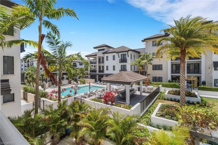 Balcony view - Western exposure, community pool featuring a spa, cabana with bar seating and gas grills