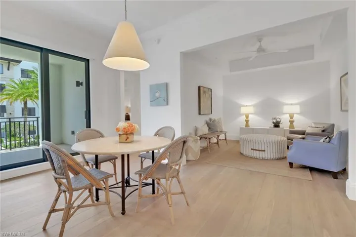 Dining area and den featuring designer lighting, ceiling fan, and french oak flooring throughout