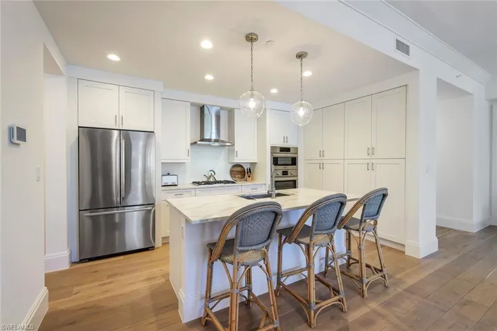 Kitchen with quartz counters, Bosch appliances, gas cooktop, tons of storage, an island with sink, white cabinetry, and appliances with stainless steel finishes