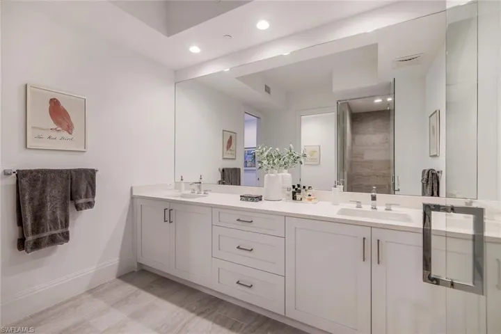 Large primary bathroom with double sinks and glass shower