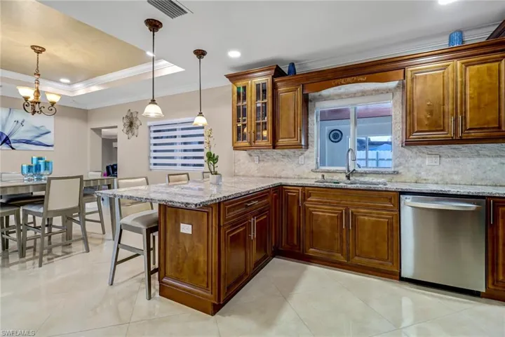 Kitchen with light tile floors, granite countertop, and stainless-steel appliances
