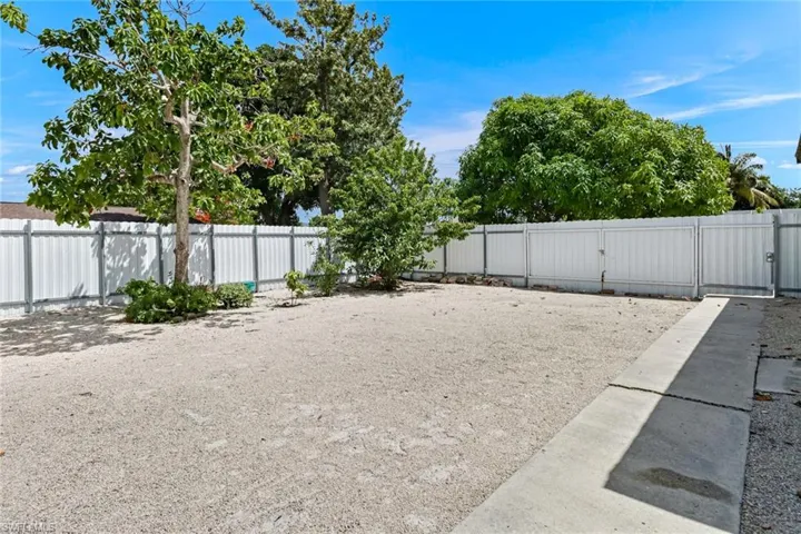 View of yard, corner lot with space for a boat or any toy.  Fully fenced with white fence and fruit trees