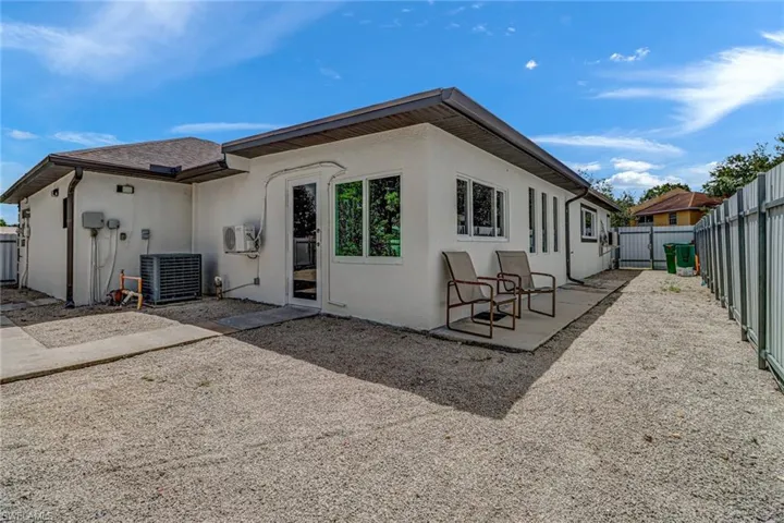 Rear view of house featuring a patio area and central AC unit, fence