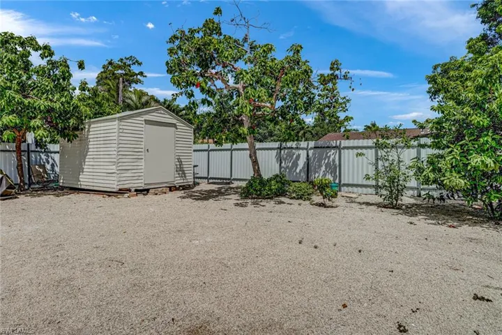 View of yard featuring a shed, corner lot fully fenced