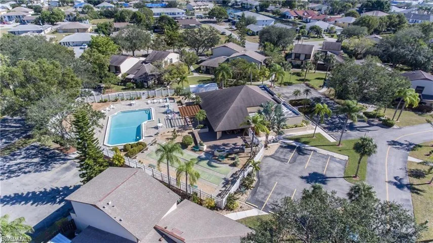 Community amenities featuring a large swimming pool, shuffleboard courts, and a spacious parking area