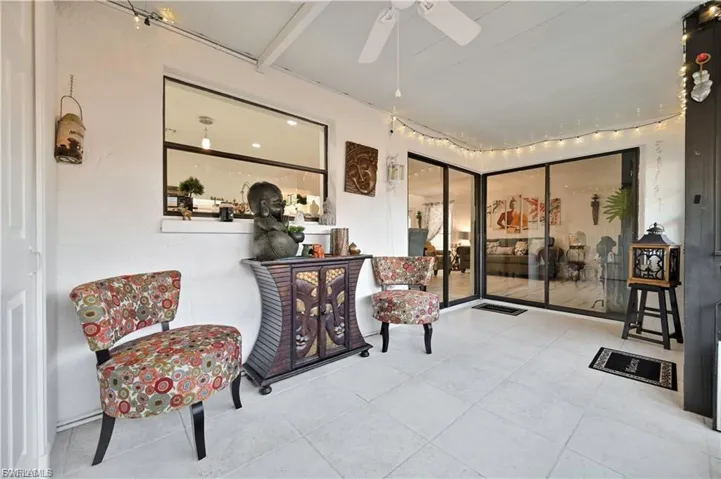 Enclosed patio featuring light-toned tile flooring and a ceiling fan