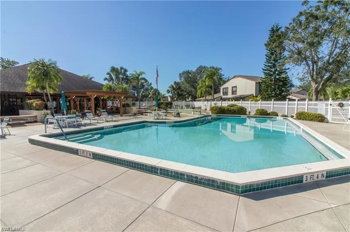Community swimming pool featuring a concrete deck and green tile trim