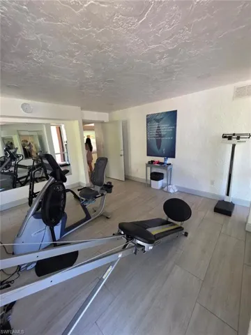 Workout area featuring a textured wall and a textured ceiling