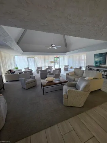 Living area featuring vaulted ceiling and a ceiling fan