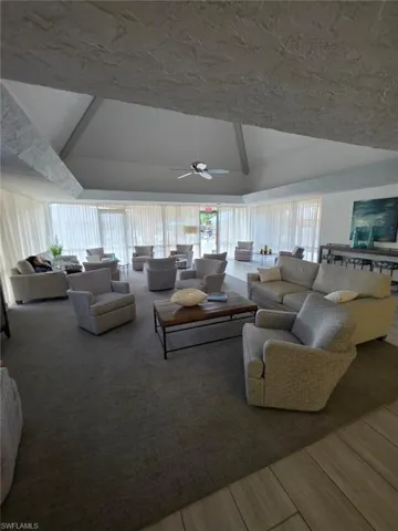 Living area with lofted ceiling and ceiling fan