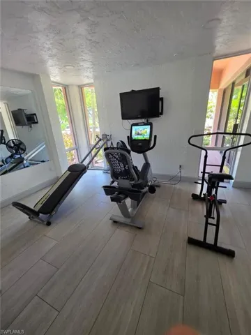 Workout area featuring a textured wall and a textured ceiling