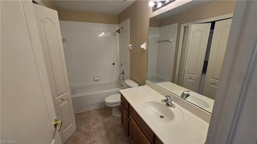 Bathroom with vanity, bathtub / shower combination, and a closet