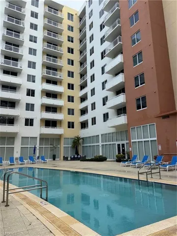 Rectangular swimming pool surrounded by a light-colored paver deck