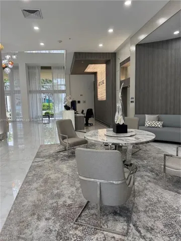 Spacious common area featuring polished tile flooring and a large area rug