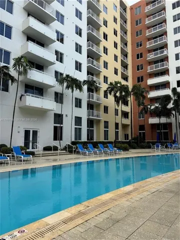 Outdoor swimming pool with a tile surround and multiple lounge chairs