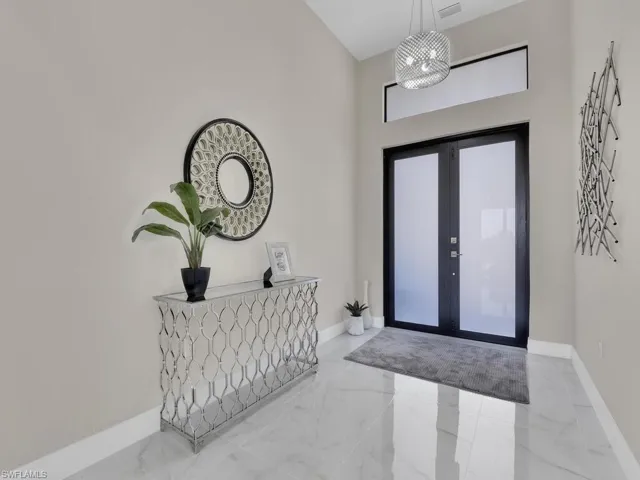 Foyer entrance with french doors, a high ceiling, and an inviting chandelier