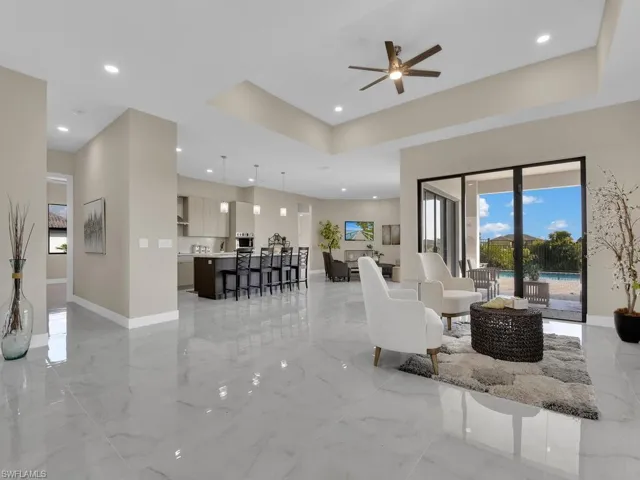 Living room with ceiling fan and a raised ceiling