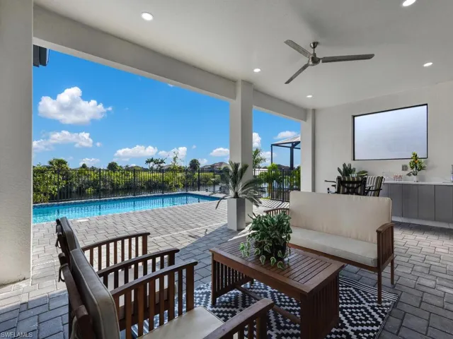 View of patio with ceiling fan and a fenced in pool