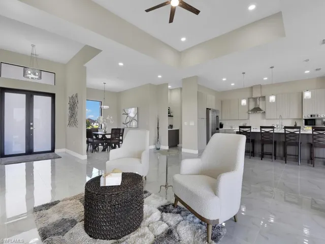 Living room with ceiling fan with notable chandelier