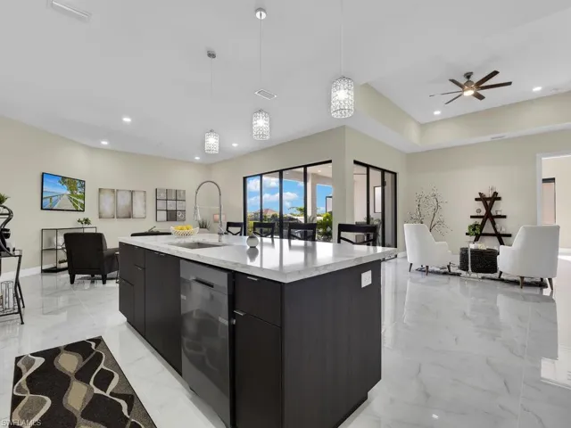 Kitchen featuring ceiling fan, sink, pendant lighting, a center island with sink, and dishwasher