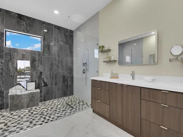 Bathroom with vanity and tiled shower