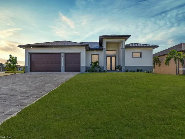 View of front of property with a garage and a lawn