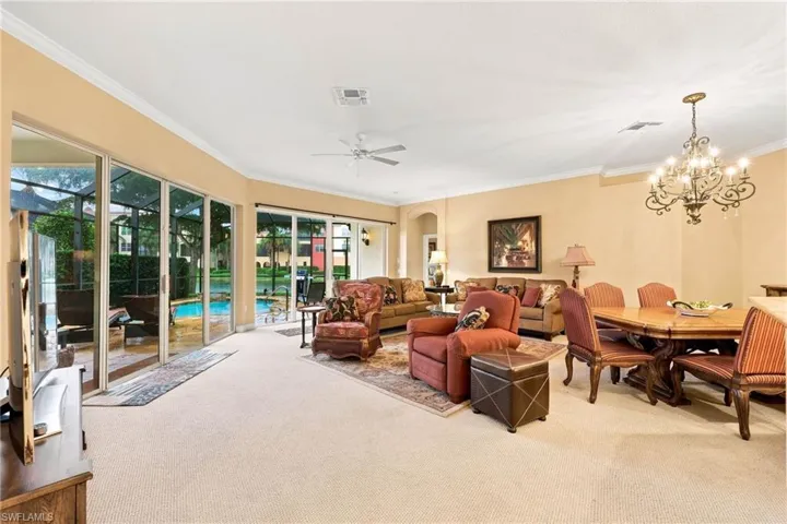 Curved wall of sliding glass doors opening to a screened lanai with a pool