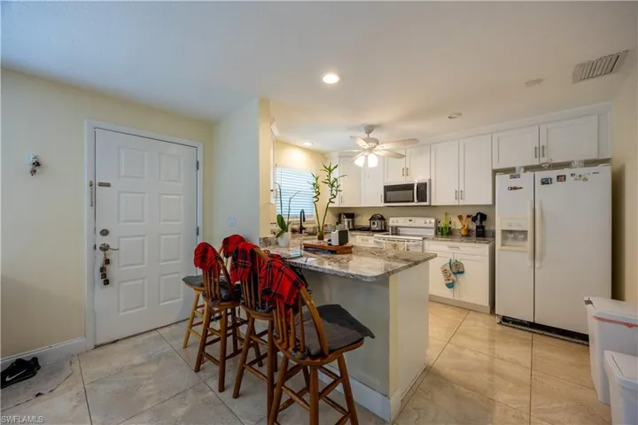Kitchen featuring white cabinetry, light-toned countertop, and stainless steel appliances