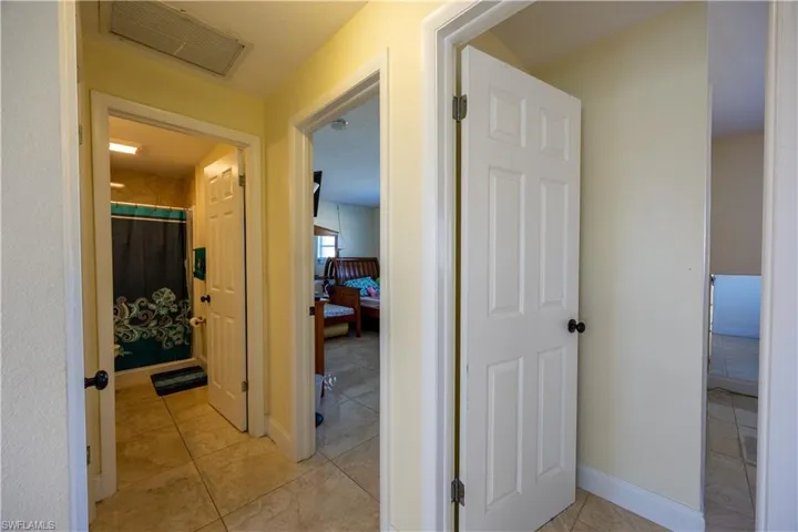 Hallway featuring tile flooring and multiple doorways