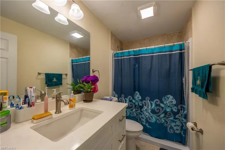 Bathroom featuring a single vanity with an integrated sink, brushed nickel faucet, and a large wall-mounted mirror