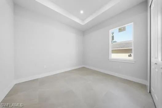 Unfurnished room with a raised ceiling and recessed lighting
