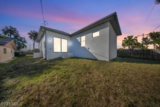 Back of house at dusk featuring stucco siding