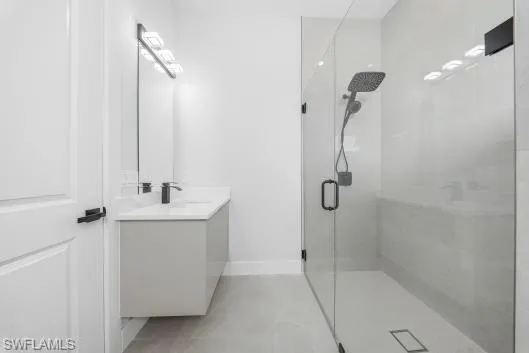 Full bathroom featuring vanity and a marble finish shower