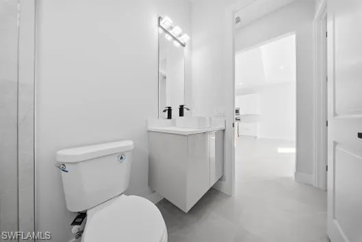 Half bathroom featuring vanity and toilet