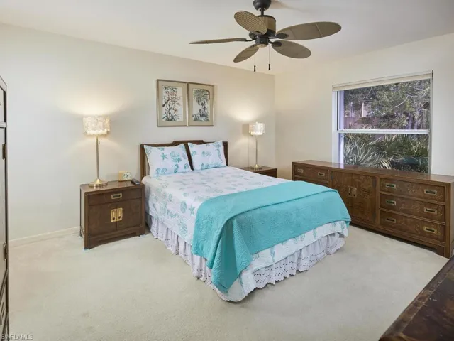 Cozy and serene bedroom with a ceiling fan and warm decor.