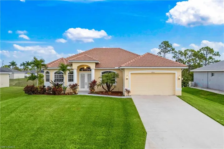 Mediterranean / spanish house featuring concrete driveway, stucco siding, and a front lawn