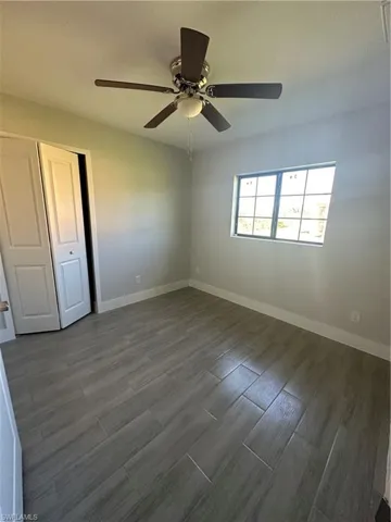 Unfurnished bedroom featuring ceiling fan, hardwood / wood-style flooring, and a closet