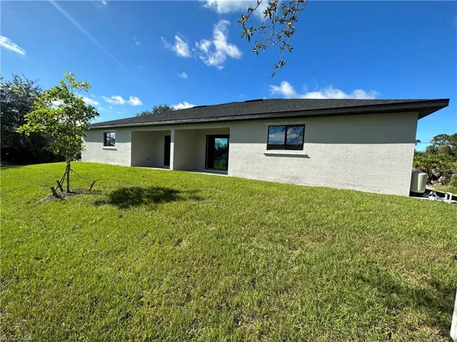 Rear view of property with a yard