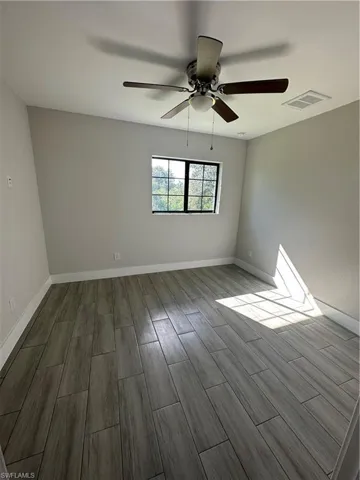 Empty room featuring wood-type flooring and ceiling fan